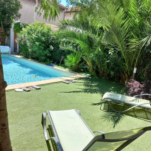 - une piscine avec une chaise et un hamac dans la cour dans l'établissement La Secrète d'Avignon, à Avignon