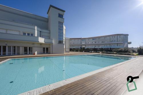 a large swimming pool in front of a building at HOTIDAY Hotel Tirrenia in Tirrenia