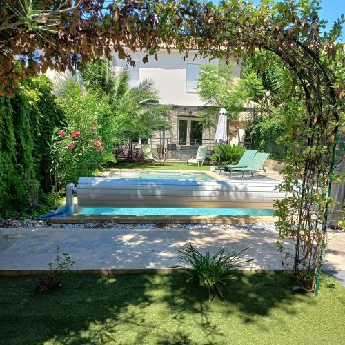 - une piscine dans une cour avec une arche dans l'établissement La Secrète d'Avignon, à Avignon