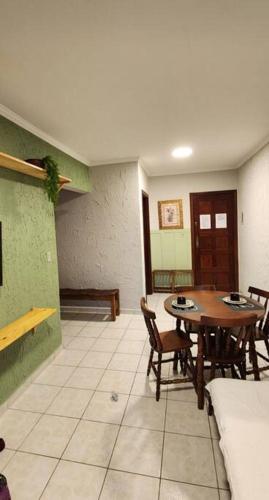 - un salon avec une table et des chaises en bois dans l'établissement Apartamento Praia Grande Aviação 50m praia, à Praia Grande
