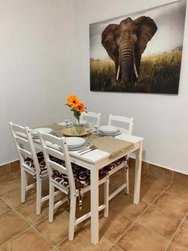 una mesa de comedor con una pintura de elefante en la pared en Apartamento Las Palomas, en Bonares