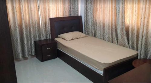 a small bedroom with a bed and a night stand at Shahed Apartment in Amman
