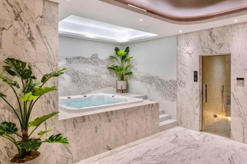 a bathroom with a jacuzzi tub and plants at Burj Khalifa Views 2BR with Infinity Pool Downtown in Dubai