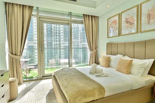 a bedroom with a large bed with a large window at Burj Khalifa Views 2BR with Infinity Pool Downtown in Dubai
