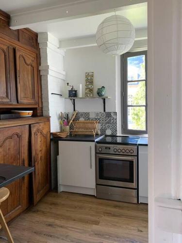 a kitchen with a stove and a window at Charmante maison dans le parc d'un château in Saint-Pierre-du-Val