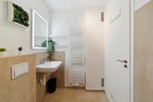 a white bathroom with a sink and a shower at Moderne Unterkunft für Monteure und Geschäftsreisende in Osnabrück