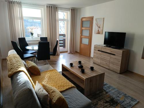 a living room with a couch and a tv at Apartamenty EDK in Jelenia Góra