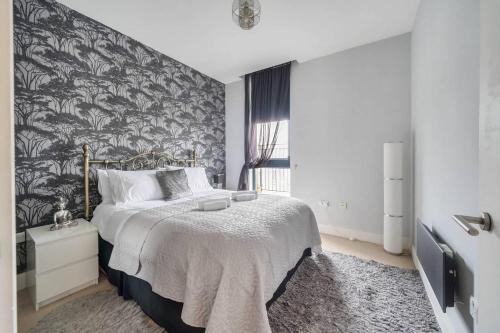 1 dormitorio con 1 cama con papel pintado en blanco y negro en Pass the Keys Liberty House · Spacious modern apartment, en Chertsey