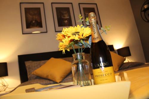 eine Flasche Champagner und Blumen auf dem Tisch in der Unterkunft St James 3 bedroom House in Tunbridge Wells in Royal Tunbridge Wells