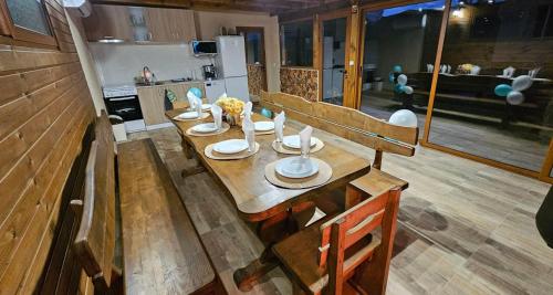 Cette chambre comprend une table en bois et une cuisine. dans l'établissement Вила Доброво, à Dobrovo