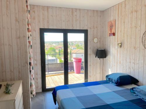 a bedroom with a blue bed and a large window at Belle villa en Provence in Lançon-Provence