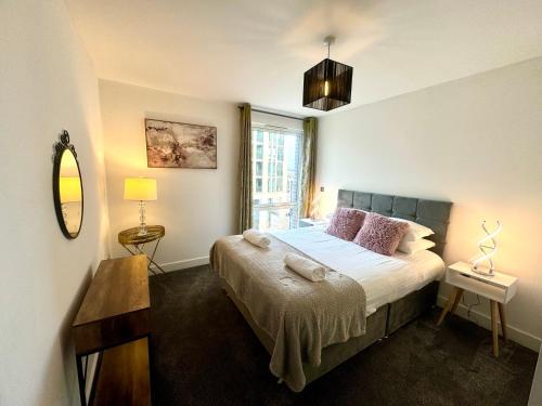 una camera da letto con un letto con specchio e una finestra di Home2home Serviced Apartment a Cambridge