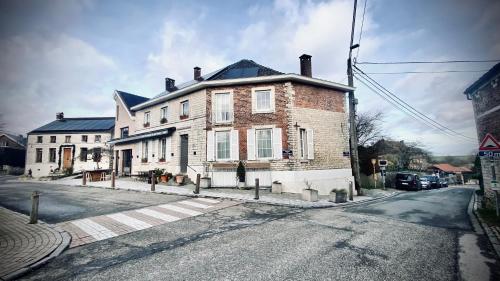 Les Chambres @ BisousBisous في Jodoigne: منزل من الطوب كبير على جانب شارع