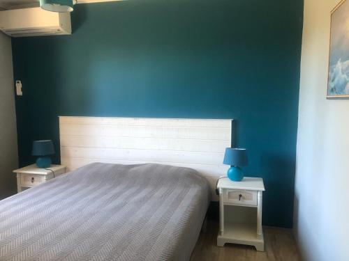 ein Schlafzimmer mit einem Bett und zwei Tischen mit Lampen in der Unterkunft VILLA AVEC PISCINE in Roussillon