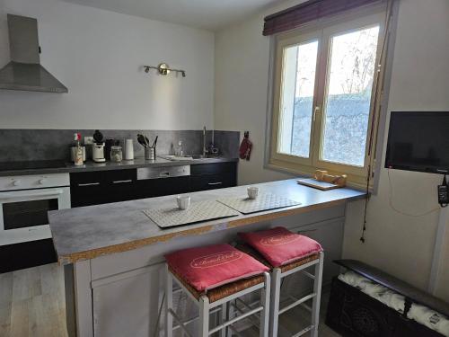 een keuken met een aanrecht met 2 krukken bij Honey Moon in Saint-Bonnet-en-Champsaur