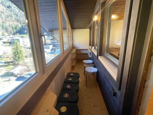 una stanza con due finestre e una fila di sgabelli di homy Alpine Deluxe Chalet in St Anton im Montafon a Sankt Anton im Montafon