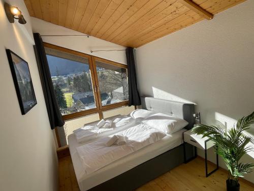 Cette chambre comprend un grand lit et une fenêtre. dans l'établissement homy Alpine Deluxe Chalet in St Anton im Montafon, à Sankt Anton im Montafon