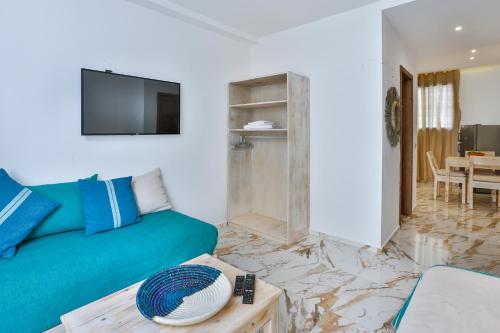 a living room with a green couch and a table at Hanah Apartments by Living Essaouira in Essaouira