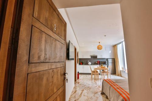 a large wooden door in a room with a kitchen at Hanah Apartments by Living Essaouira in Essaouira