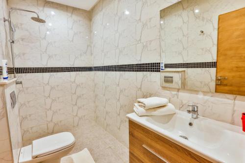 a white bathroom with a sink and a toilet at Hanah Apartments by Living Essaouira in Essaouira