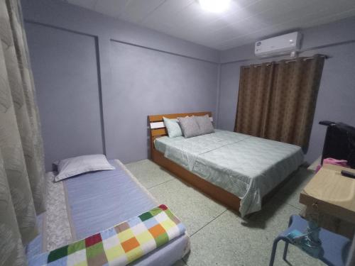 - une petite chambre avec 2 lits et une fenêtre dans l'établissement บ้านพักมาซามิโฮม หาดเจ้าสำราญ Mazami Homes At Chao Samran Beach Phetchaburi, à Ban Hat Cha Samran
