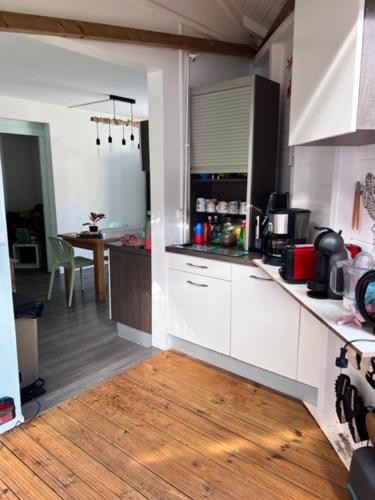 een keuken met witte kasten en een houten vloer bij Appartement face à l'ilet Gosier in Le Gosier