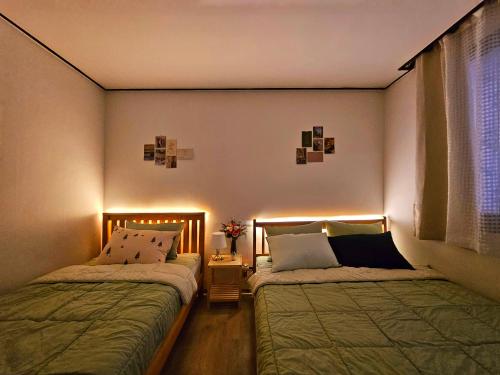 two beds sitting in a room with lights at Romantic sillim in Seoul