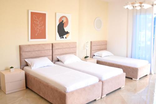 two beds in a room with white walls at CAPTAIN'S RESIDENCE in Ksamil