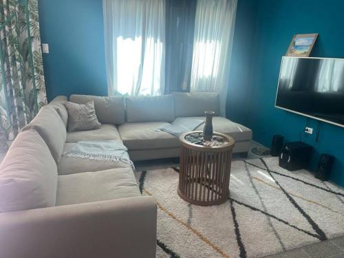 een woonkamer met een witte bank en een tv bij Whispering Clouds Beach House in Kings Pen