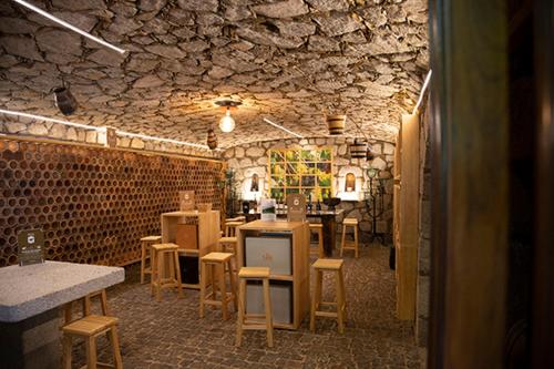 a room with chairs and tables and a stone wall at Casa De Crespins Casa de Campo Lda in Cristelo