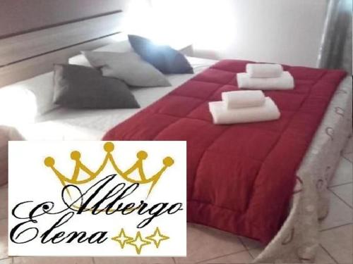 un grande letto con un piumone rosso e una corona sopra di camera residence a Parma