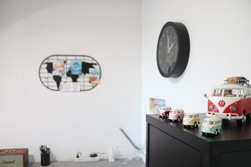 une chambre avec une horloge et des voitures jouets sur une commode dans l'établissement T2 moderne, vintage & cosy, à Sète