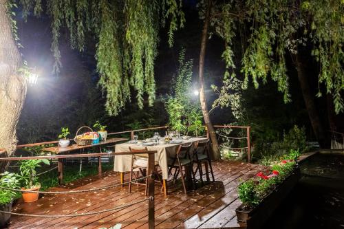 a wooden deck with a table and chairs on it at Conacul Malul Alb in Râmnicu Vâlcea