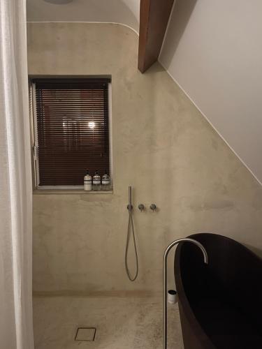 a bathroom with a shower with a window at Appartement aan prachtig rivierenlandschap in Temse