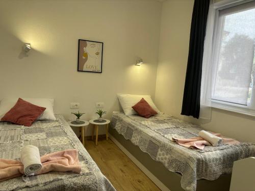 a bedroom with two beds and a window at City Center Suite Novalja in Novalja