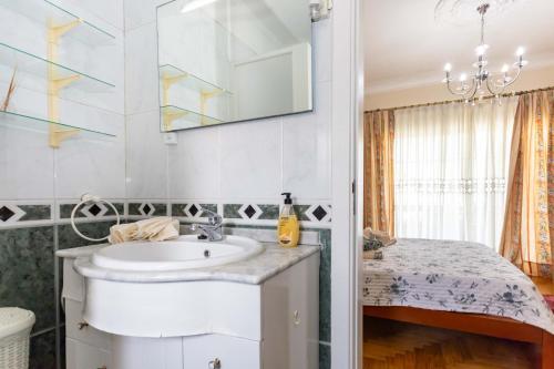 a bathroom with a sink and a mirror at Casa Ze da Cotta Marisol in Corroios