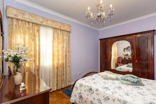 a bedroom with a bed with a dresser and a mirror at Casa Ze da Cotta Marisol in Corroios
