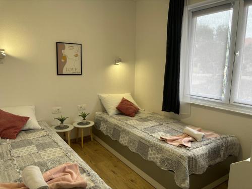 a bedroom with two beds and a window at City Center Suite Novalja in Novalja
