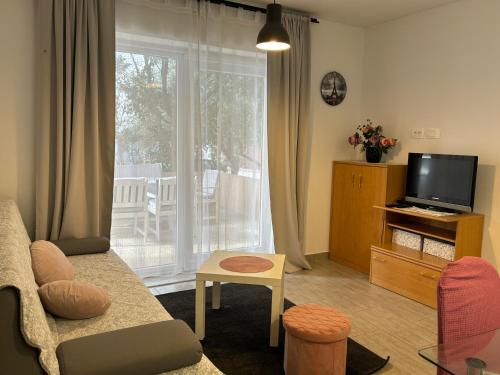 a living room with a couch and a tv at City Center Suite Novalja in Novalja
