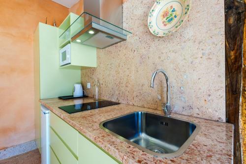uma cozinha com um lavatório e um prato na parede em Quinta da Cortiça - Casa da Torre em Alvaiázere