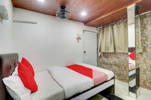 a small bedroom with a bed and a shower at Hotel Memsaab Family Residency in Mumbai
