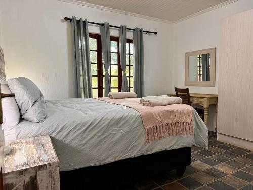 a bedroom with a large bed and a desk at Aurora Bushbaby 2 in Centurion