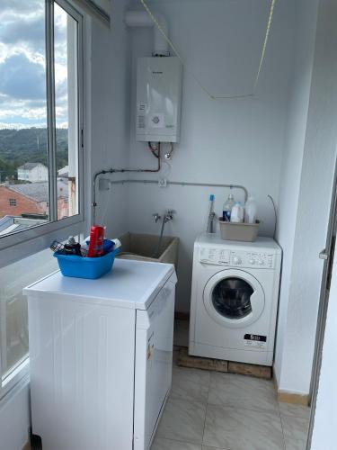 a laundry room with a washing machine and a window at Piso turístico Baralla in Baralla