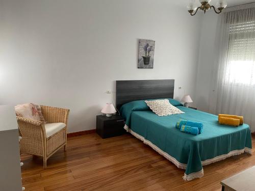 Apartamento Cuca في Baralla: غرفة نوم فيها سرير وكرسي