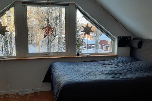 een slaapkamer met een bed en 2 ramen met sterren bij Exklusive villa on the coast close to Stockholm in Åkersberga
