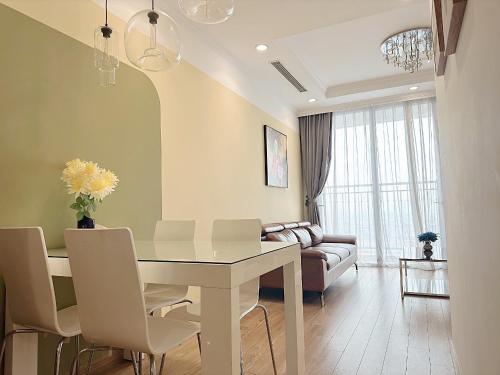 - un salon avec une table et des chaises blanches dans l'établissement Tpland Việt Nam - Vinhomes Times City- Park Hill, à Hanoï