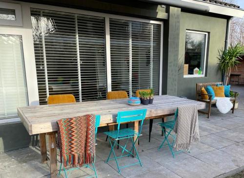 una mesa de madera y sillas en un patio en Costa Linda B&B, en Vlissingen