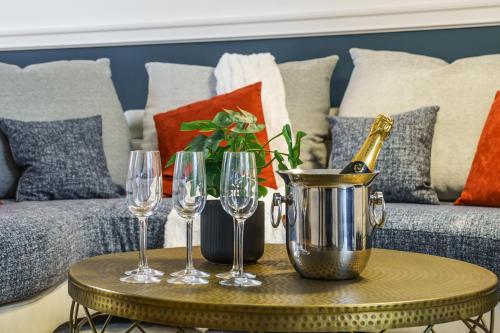 un tavolo con bicchieri da vino e una bottiglia di champagne di La Cour de l'Opera - PrestiPlace Tours a Tours