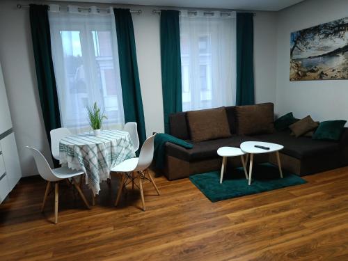 uma sala de estar com um sofá, uma mesa e cadeiras em Apartament 55m2 for you em Szczawno-Zdrój