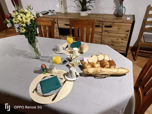 een tafel met een bord brood en glazen sinaasappelsap bij ESCAPADE BELINOISE in Moncé-en-Belin